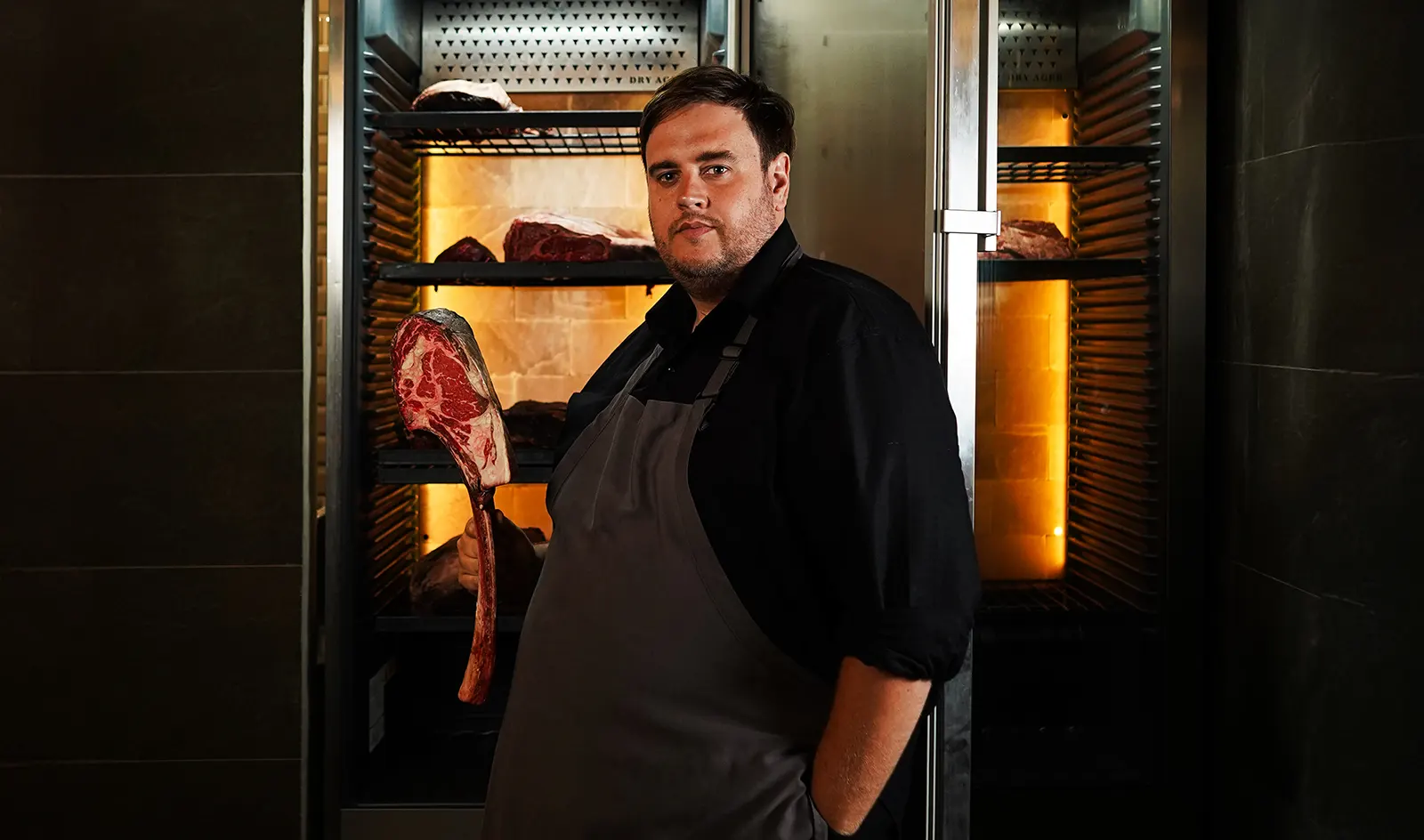 A chef holding a T-bone steak